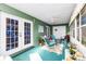 Screened lanai featuring rocking chairs with view of stained glass doors at 1452 Grand Cayman Cir, Winter Haven, FL 33884