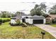 Charming single-story home boasts a fresh white exterior, landscaping, and a two-car garage at 1535 New Jersey Oaks Ct, Lakeland, FL 33801