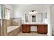 Bathroom featuring dual sinks and a soaking tub with tile surround at 1561 Shorewood Dr, Auburndale, FL 33823