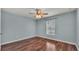 Light blue bedroom with wood floors and window at 1570 Doves View Cir, Auburndale, FL 33823