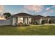 House exterior at dusk, showcasing landscaping and garage at 1570 Doves View Cir, Auburndale, FL 33823