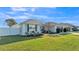Well-maintained single-story home featuring an expansive green lawn, lush landscaping, and attached two car garage at 1570 Doves View Cir, Auburndale, FL 33823