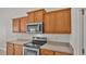 Modern kitchen with stainless steel appliances and wood cabinets at 1570 Doves View Cir, Auburndale, FL 33823