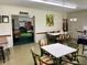 Bright community room with game tables and a view into a fitness area at 1700 6Th Nw St # C27, Winter Haven, FL 33881