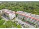 Condo building with surrounding parking and lush trees at 200 El Camino Dr # 309, Winter Haven, FL 33884