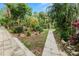 Landscaped backyard with pond and walkway at 200 El Camino Dr # 309, Winter Haven, FL 33884