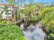 Serene pond with fountain, lush landscaping, and building view at 200 El Camino Dr # 309, Winter Haven, FL 33884