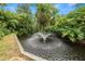 Serene pond with fountain, lush tropical landscaping at 200 El Camino Dr # 309, Winter Haven, FL 33884
