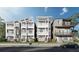 Charming exterior elevation showcasing three-story homes, manicured lawns, and inviting balconies under a bright blue sky at 23 Lake Hollingworth, Lakeland, FL 33803