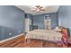 Bedroom with blue walls, wood floors, a bed, and access to bathroom at 2507 Torrens Dr, Lakeland, FL 33805