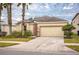 Charming single-story home with a two-car garage, well-maintained lawn, and tropical landscaping with palm trees at 2507 Torrens Dr, Lakeland, FL 33805