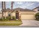 One-story house with beige walls, a two-car garage, and lush landscaping at 2507 Torrens Dr, Lakeland, FL 33805