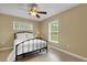Simple bedroom with a white iron bed and two windows at 2620 Jonila Ave, Lakeland, FL 33803
