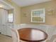 Charming dining area with round wooden table and white chairs, adjacent to laundry at 2620 Jonila Ave, Lakeland, FL 33803