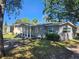Charming single-story home featuring a covered front porch and light gray wood siding at 3016 Hutchins St, Eaton Park, FL 33840