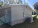 Side view of home featuring light gray siding, white trim, and a modern HVAC unit at 3016 Hutchins St, Eaton Park, FL 33840