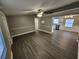 Open-concept living room and kitchen area, featuring wood-look floors and modern appliances at 3016 Hutchins St, Eaton Park, FL 33840