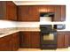 Dark wood cabinets, black appliances, and a view into the dining area at 3648 Julius Estates Blvd, Winter Haven, FL 33881