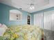 Bedroom with light teal walls, ceiling fan, and tropical bedding at 4463 Pebble Pointe Dr, Lakeland, FL 33813