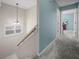 Upstairs hallway with neutral carpeting and a staircase at 4463 Pebble Pointe Dr, Lakeland, FL 33813