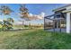 Landscaped backyard with covered patio and water views at 5272 Riverlake Dr, Bartow, FL 33830