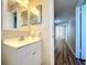 Clean bathroom with white vanity, mirror, and hallway view at 646 Cottage Ln, Lakeland, FL 33803