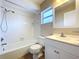 Updated bathroom with white vanity, tub, and tiled flooring at 646 Cottage Ln, Lakeland, FL 33803