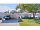 Front view of charming single story home with carport and mature landscaping at 646 Cottage Ln, Lakeland, FL 33803