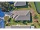 Aerial view of a home with a pristine roof, manicured lawn, and verdant landscaping, next to a small pond at 6555 Lake Clark Dr, Lakeland, FL 33813