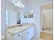 Bathroom with granite countertop, white cabinets, and a view into the laundry room at 6555 Lake Clark Dr, Lakeland, FL 33813