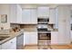 Kitchen boasts stainless steel appliances, white cabinets, and granite countertops at 6555 Lake Clark Dr, Lakeland, FL 33813