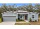 Single-story home with gray siding, solar panels, and a two-car garage at 812 Del Prado Dr, Kissimmee, FL 34758