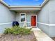 Inviting front porch with rocking chair and grill, next to a red door at 812 Del Prado Dr, Kissimmee, FL 34758