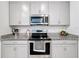 Modern kitchen with gray cabinets, granite countertops, and stainless steel appliances at 812 Del Prado Dr, Kissimmee, FL 34758