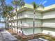 Inviting condo complex featuring multiple balconies, lush landscaping, and tranquil waterfront views at 1130 N Lake Parker Ave # A306, Lakeland, FL 33805