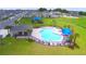 Aerial view of community pool, surrounding lounge chairs, and playground at 1214 Tagliamento Ln, Haines City, FL 33844