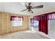 Bedroom with wood paneling, carpet, and window coverings at 127 Colonial Dr, Auburndale, FL 33823