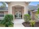 Welcoming covered entryway with double doors and lush landscaping at 1423 Royal Forest Loop, Lakeland, FL 33811