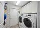 Laundry room with washer, dryer, and ample cabinet space at 1423 Royal Forest Loop, Lakeland, FL 33811