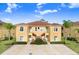 Tan two-story building with red staircases, surrounded by landscaping at 16202 Indian Creek Dr # 16202, Kissimmee, FL 34759