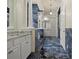 Luxurious bathroom with blue marble tile, a soaking tub, and a double vanity at 1665 Blue Heron Ln, Lakeland, FL 33813