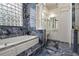 Spa-like bathroom with soaking tub, marble tile, and large window at 1665 Blue Heron Ln, Lakeland, FL 33813