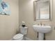 Stylish powder room with pedestal sink and decorative mirror at 1665 Blue Heron Ln, Lakeland, FL 33813