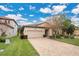 Tan house with a beige garage door and a brick paver driveway at 1832 Prima Vista Dr, Lakeland, FL 33810