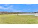 Grass backyard with pond view and partially visible fence at 1915 Pristine Loop, Lakeland, FL 33811