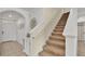 Beige carpeted staircase with white railing and entryway view at 1915 Pristine Loop, Lakeland, FL 33811