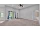 Spacious living room featuring neutral carpet, vaulted ceilings, and sliding glass doors to lanai at 212 Kissengen Park Dr, Bartow, FL 33830
