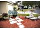 Ornate bench and bird bath accent a charming front yard with red mulch and landscaping at 2141 Sandy Hook, Lakeland, FL 33813