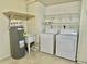 Bright laundry room with washer, dryer, utility sink, and shelving at 2141 Sandy Hook, Lakeland, FL 33813