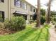 Green lawn, and vegetation lead to a patio with an awning, sliding doors, and the building facade at 223 Windsor St # 3A, Lakeland, FL 33803